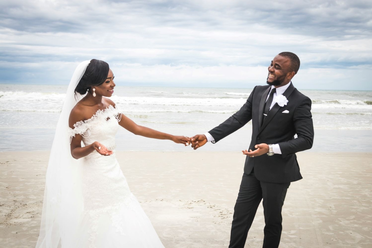 bride and groom in wedding attire on beach